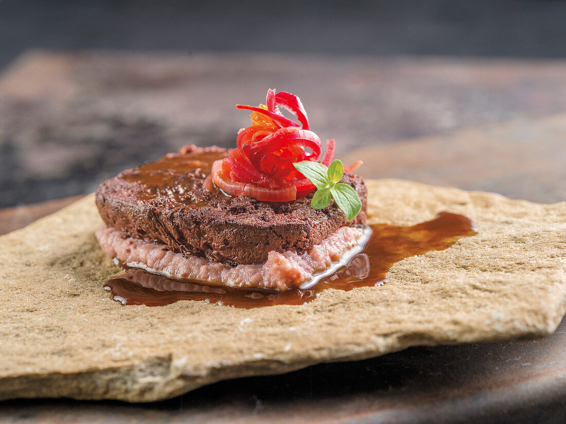 Homemade black pudding with red onion relish and mashed potatoes