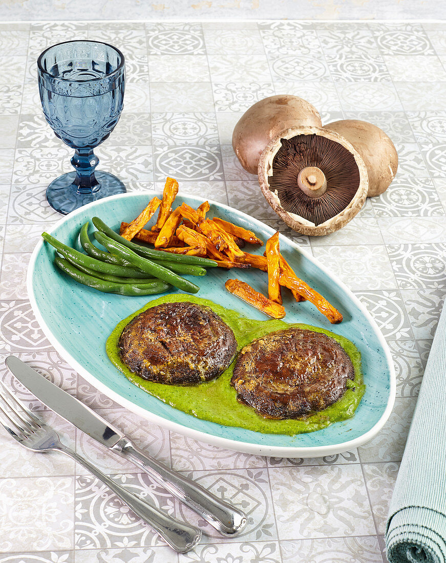 Portobello mushroom steaks on a green herb sauce