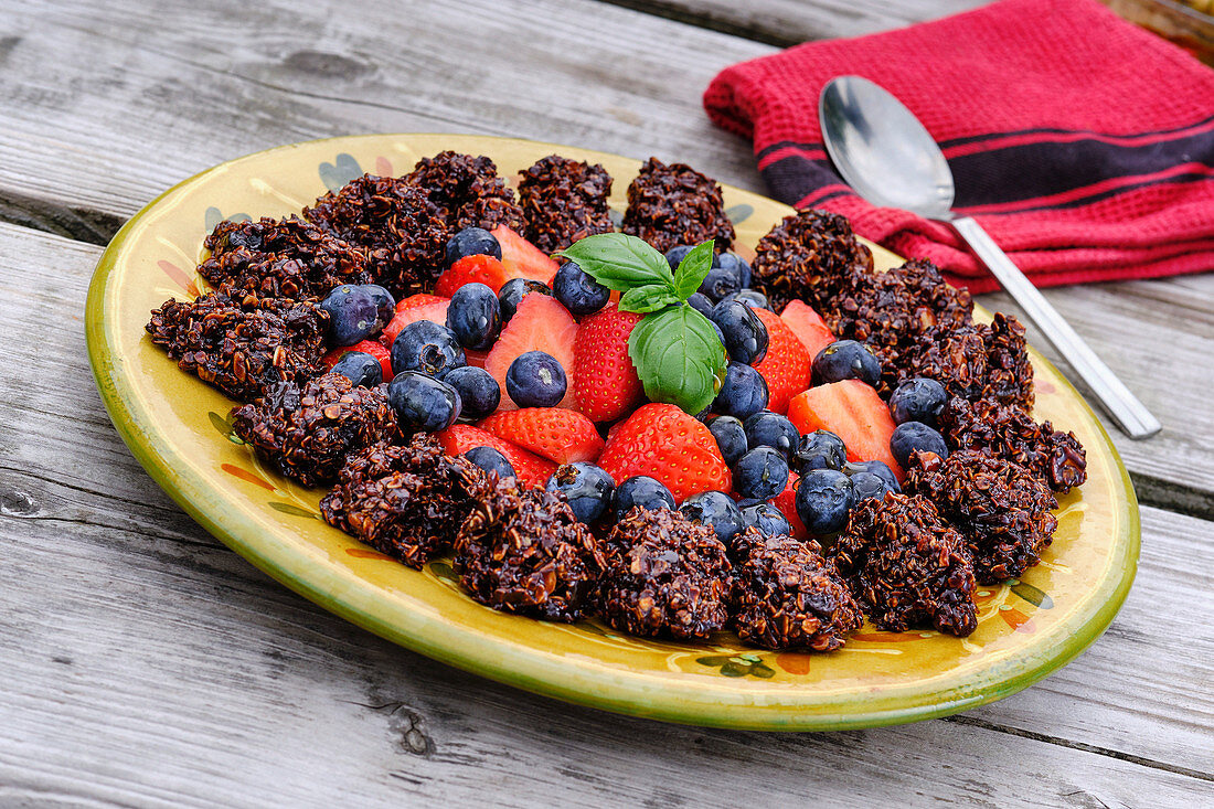Hafer-Schokoladenkonfekt mit frischen Früchten auf Servierplatte