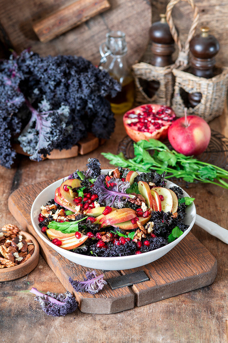 Grünkohlsalat mit violettem Grünkohl, Äpfeln, Granatapfelkernen und Nüssen