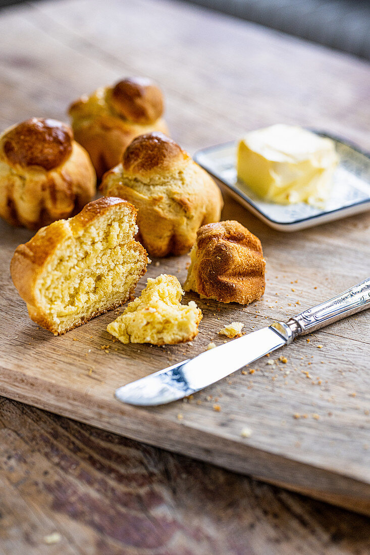 Brioches with butter on a wooden cutting board