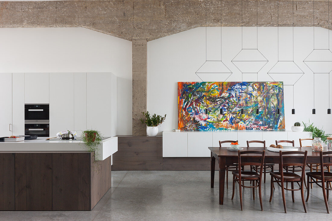 Open-plan kitchen, dining table and high ceiling in large interior