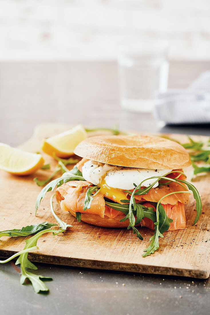 A smoked salmon bagel with a poached egg and rocket