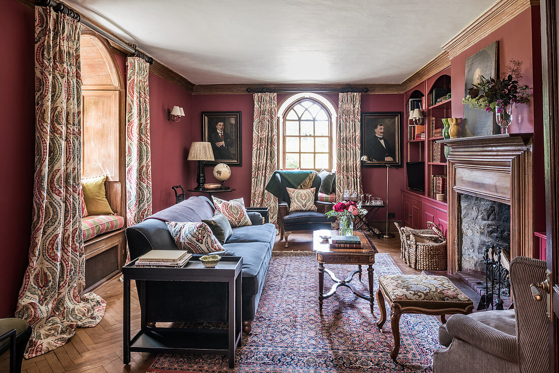 Upholstered furniture, a fireplace and a portrait painting in a living room