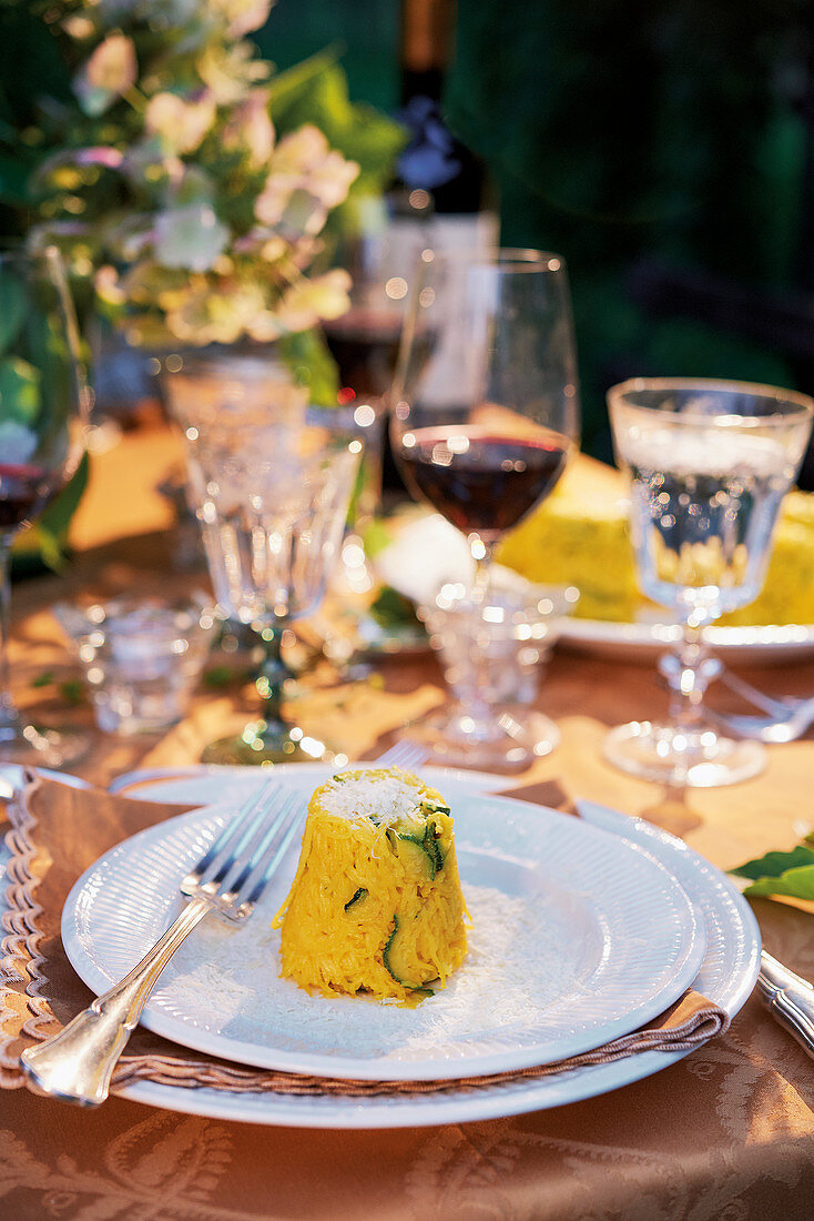 Mini-Reistimbale mit Zucchini und Safran auf gedecktem Tisch (Italien)
