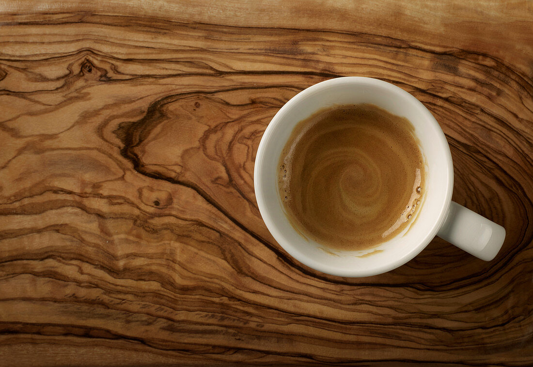 Freshly brewed espresso on an olive wood surface
