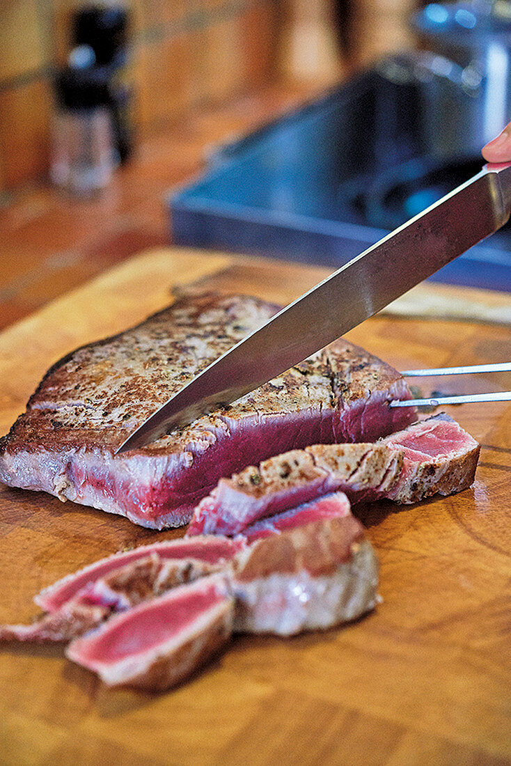 Seared tuna steak being cut into strips