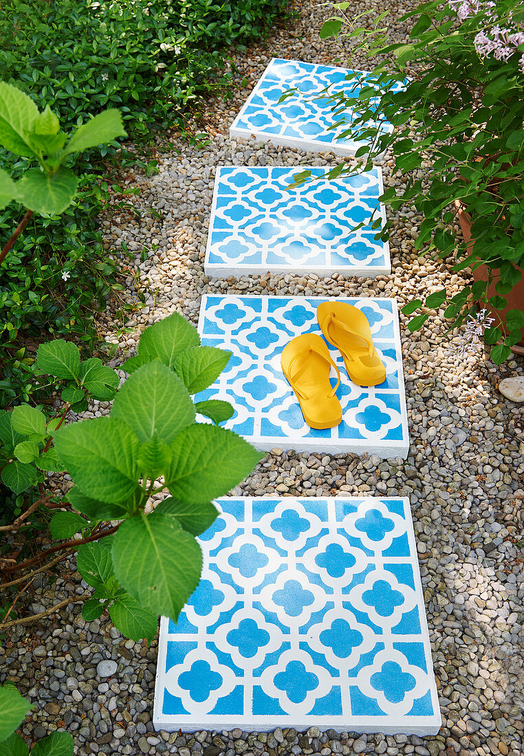 Mit Ornamenten verzierte Betonfliesen als Wegplatten im Garten