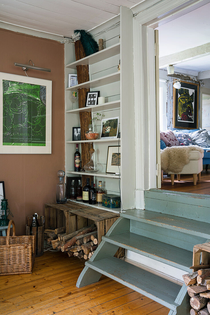 Firewood and wooden shelves in a dining room with wooden steps leading to the living room