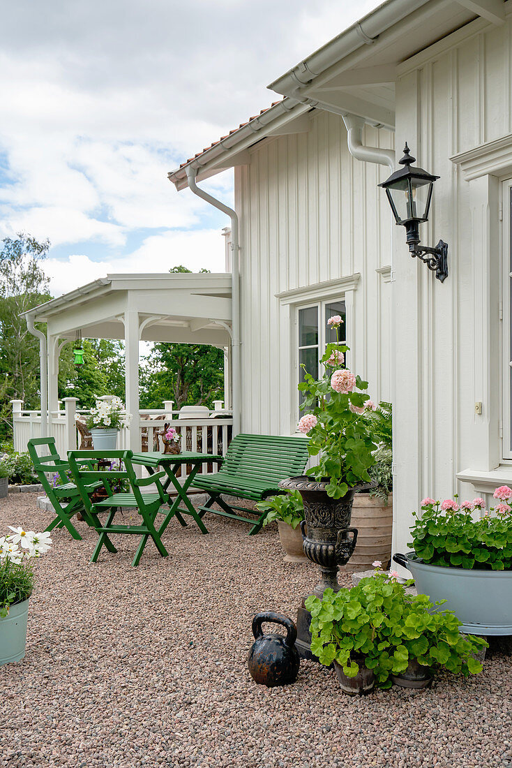 Terrassenplatz mit grünen Gartenmöbeln vor Holzhaus