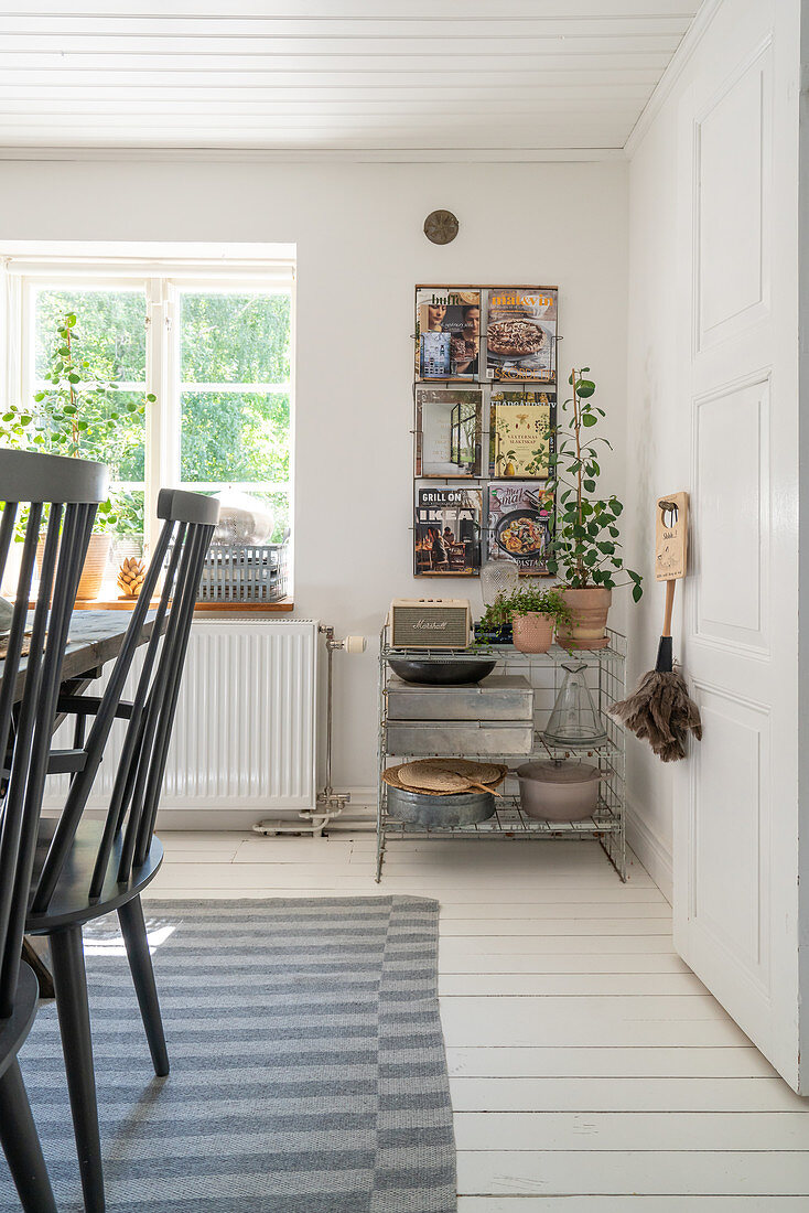 A view of a shelf and a magazine rack in a dining room