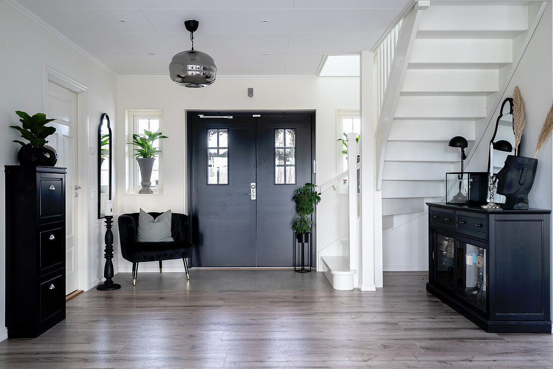 Black furniture and white stairs in a hallway
