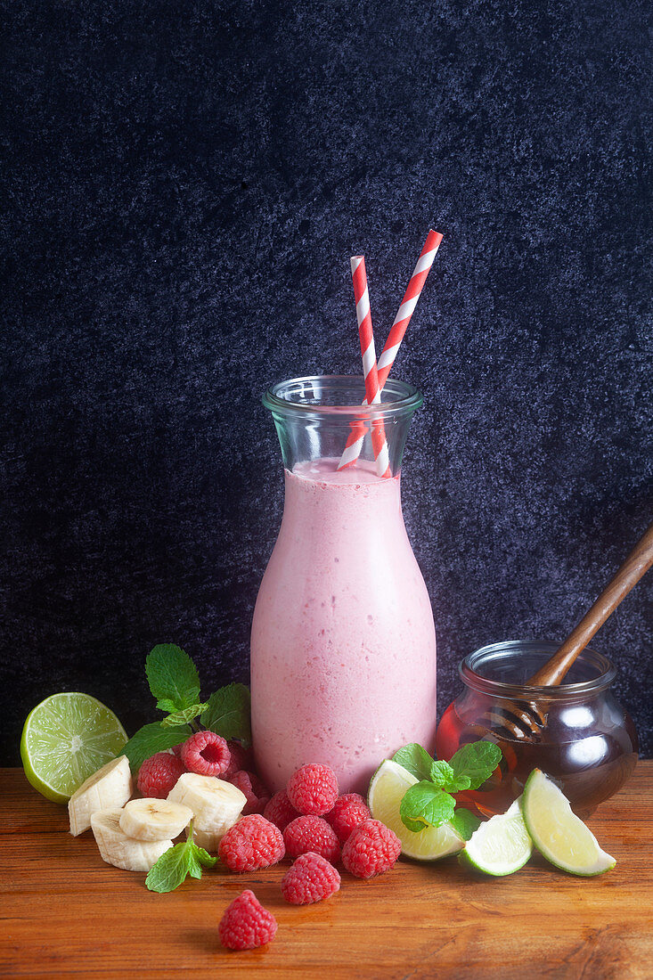 A raspberry smoothie in a glass bottle