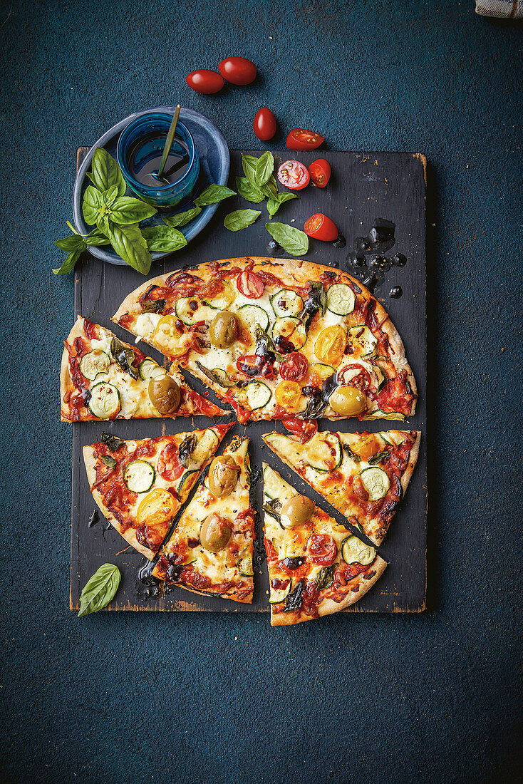 Gemüsepizza mit Zucchini, Datteltomaten, Oliven und Ricotta