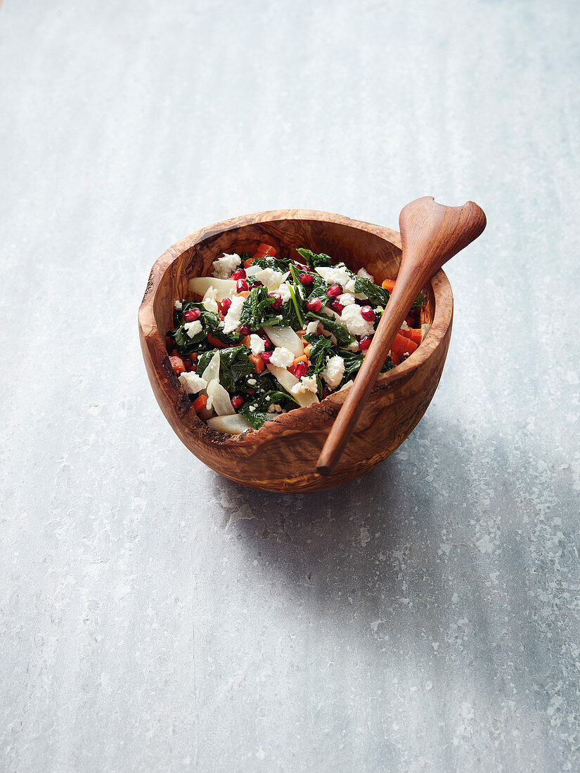 Warm kale salad with root vegetables, feta cheese and pomegranate