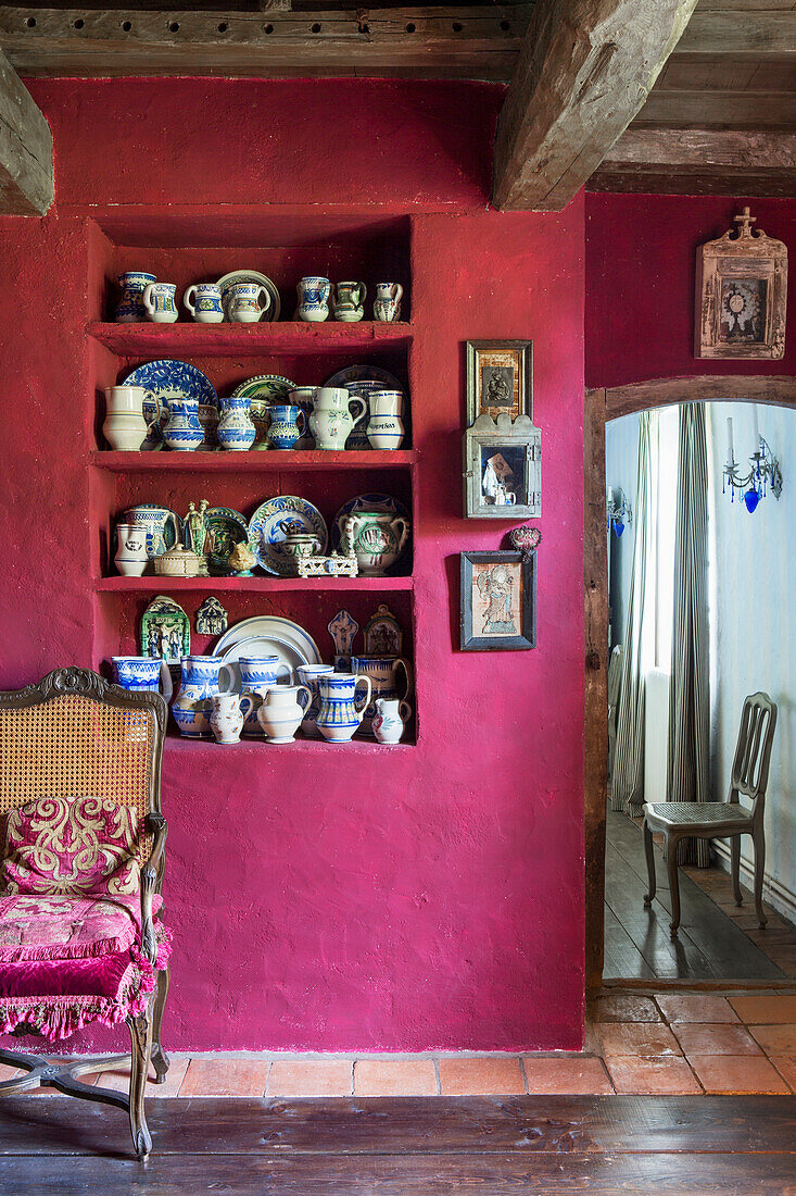 Crockery collection in niche in purple wall