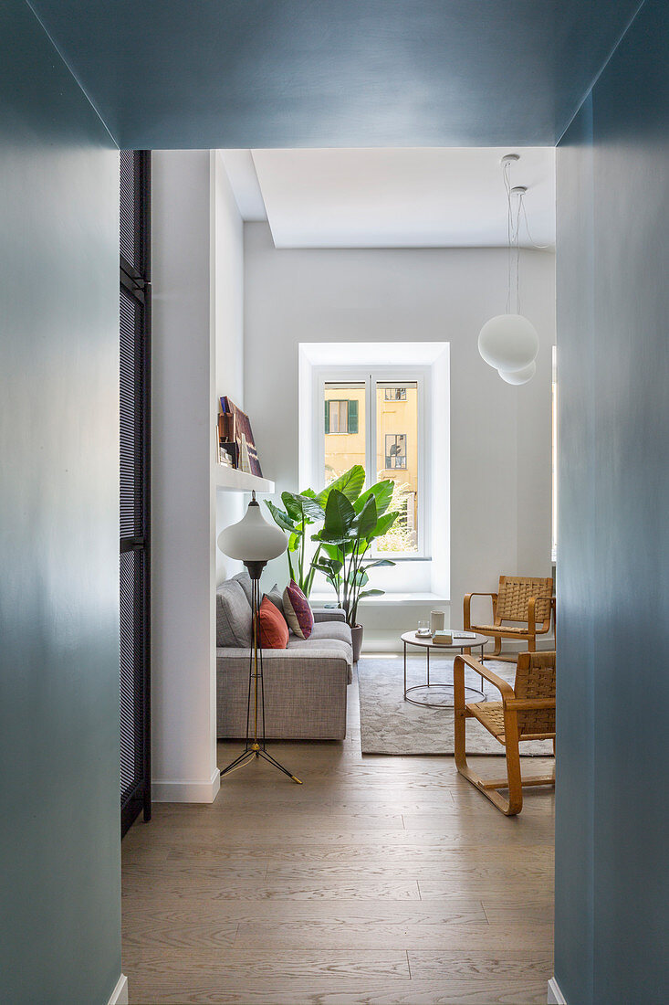 A view into a living room with a sofa and a floor lamp