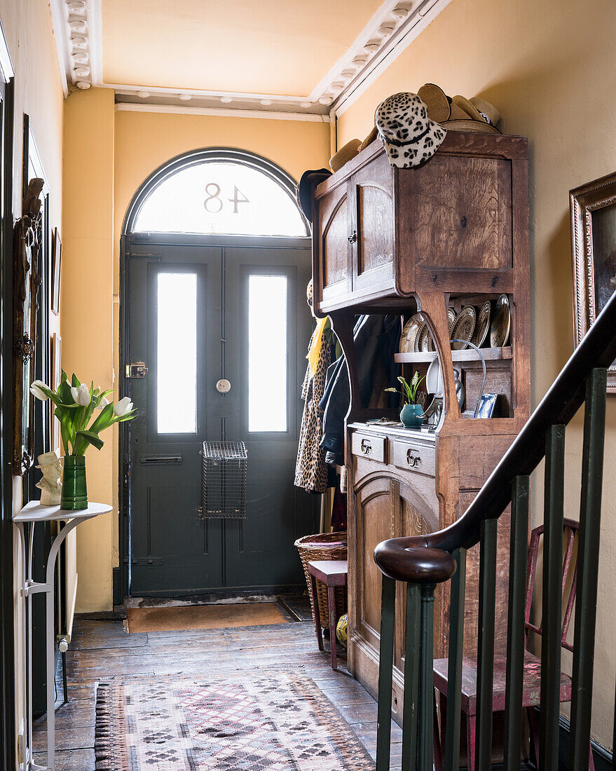 Antique wooden cabinet in hallway with lettercage on back of front door