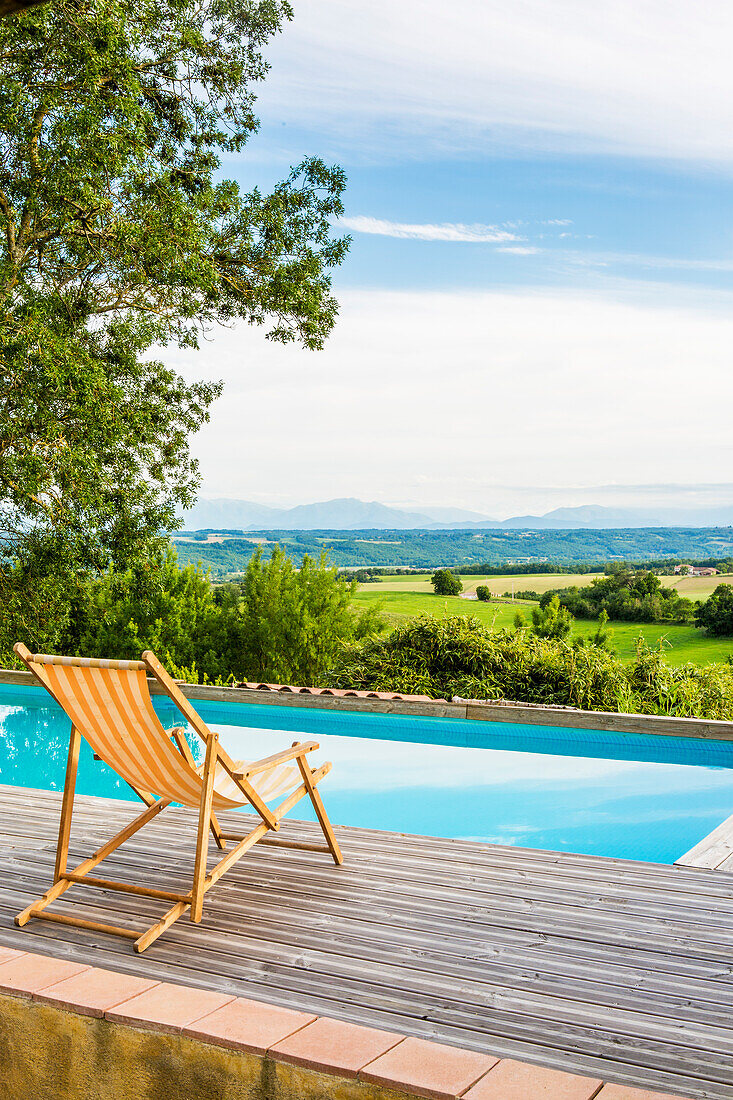 Deck chair by the pool with landscape view