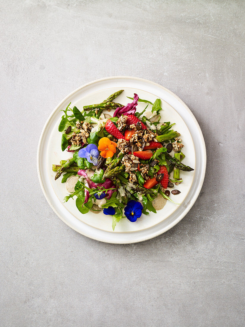 Spring salad with asparagus, buckwheat granola and edible flowers