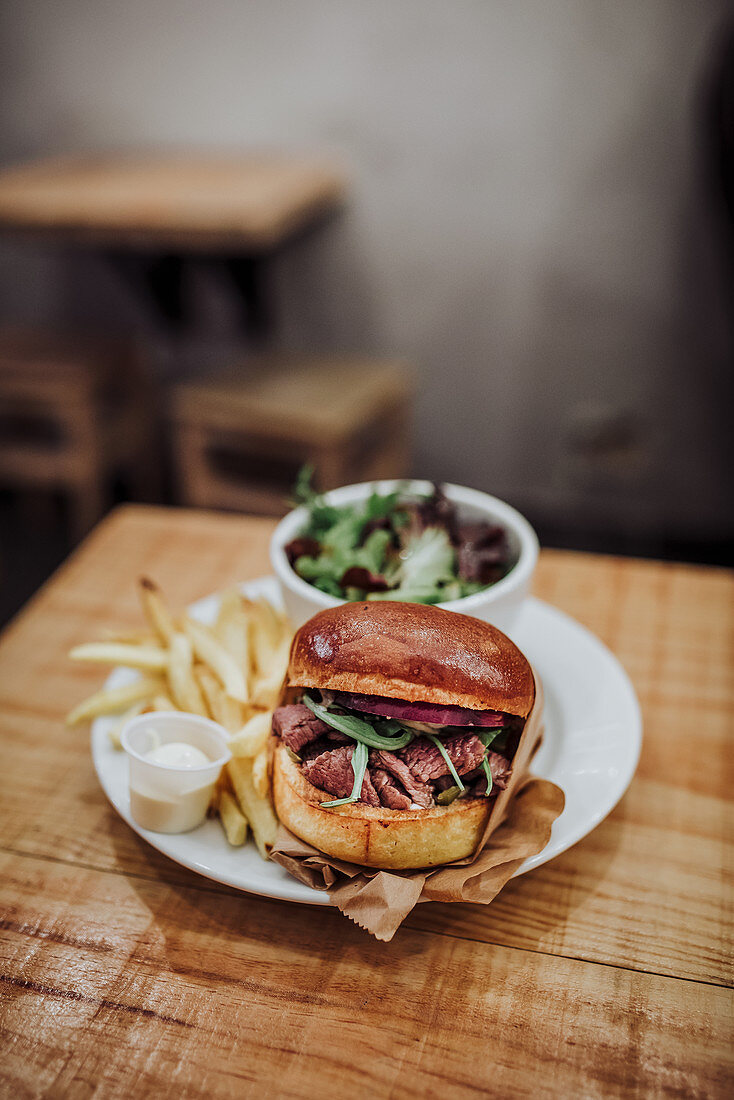 Pulled beef burger served with salad and fries