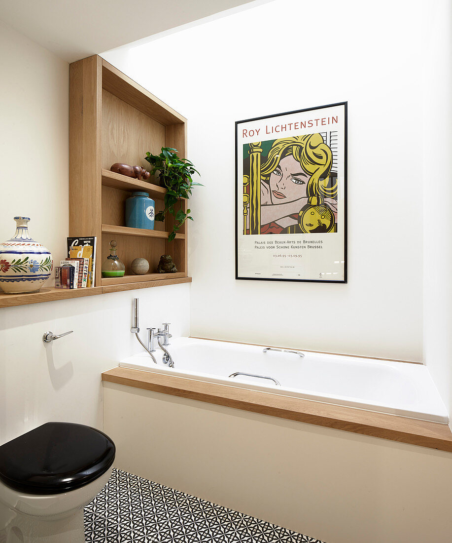 Poster above fitted bathtub in modern bathroom with skylight