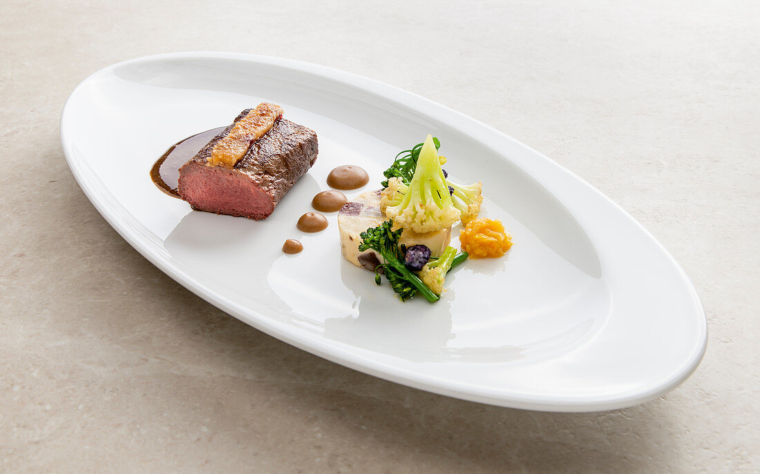 Saddle of venison in a peanut crust with ginger and orange confit