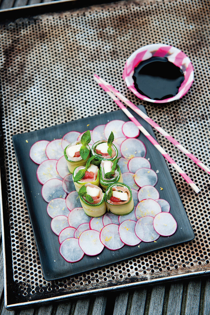 Mozzarella and courgette sushi with Parma ham on a bed of radishes