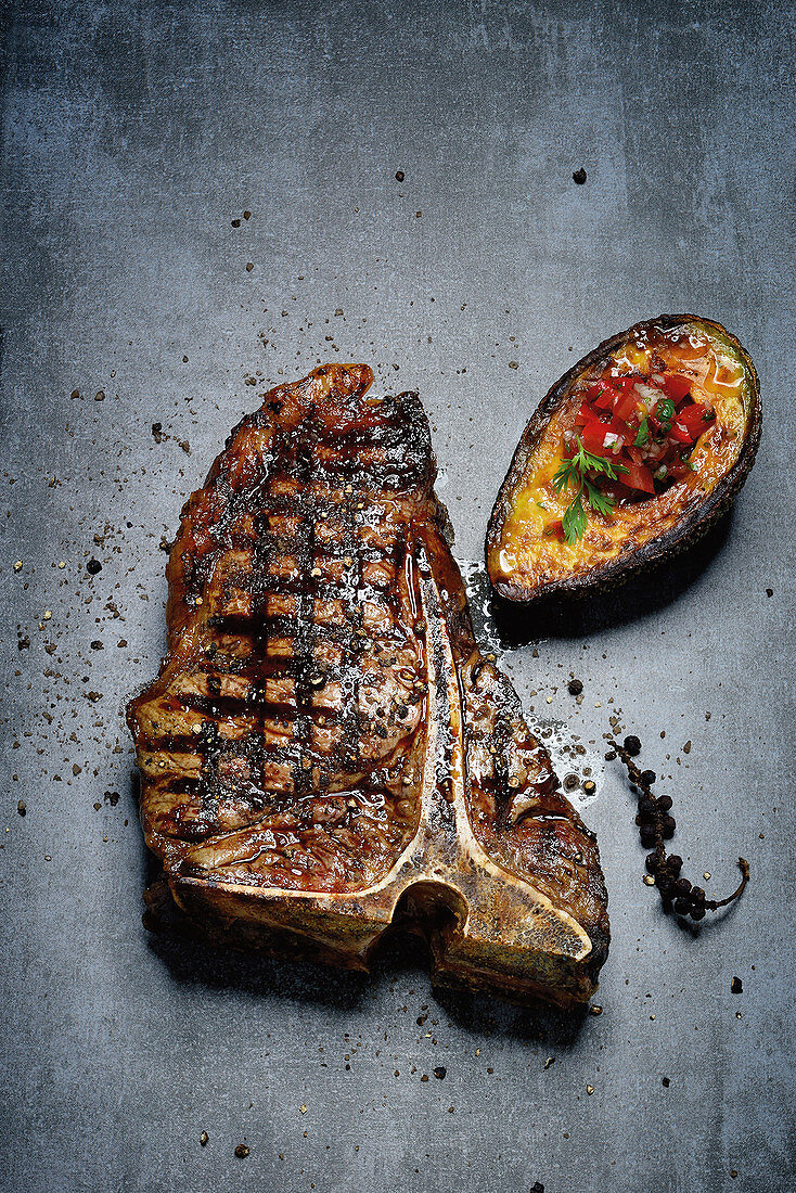 T-bone steaks with grilled avocado and tomato and coriander salsa