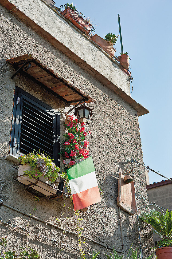 Fassadenausschnitt mit Blumenkasten und italienischer Fahne
