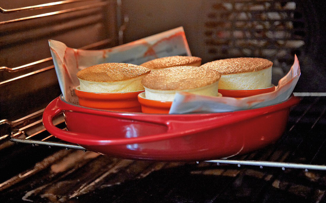 Sour cream soufflés being baked in an oven