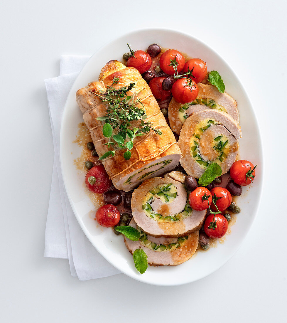 Stuffed herb roast veal with roast tomatoes and olives