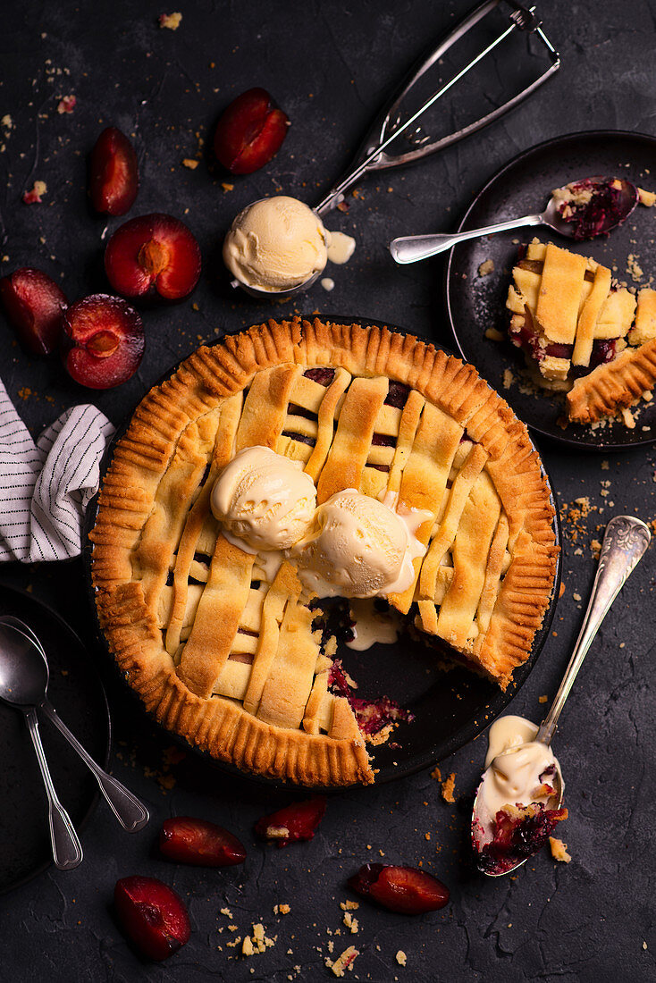 Classic shortcrust tart with plums served with a scoop of vanilla ice cream