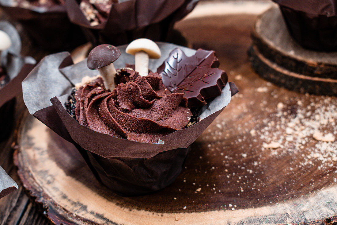 Schokoladen-Cupcakes mit Ganache und Schokoladenpilzen