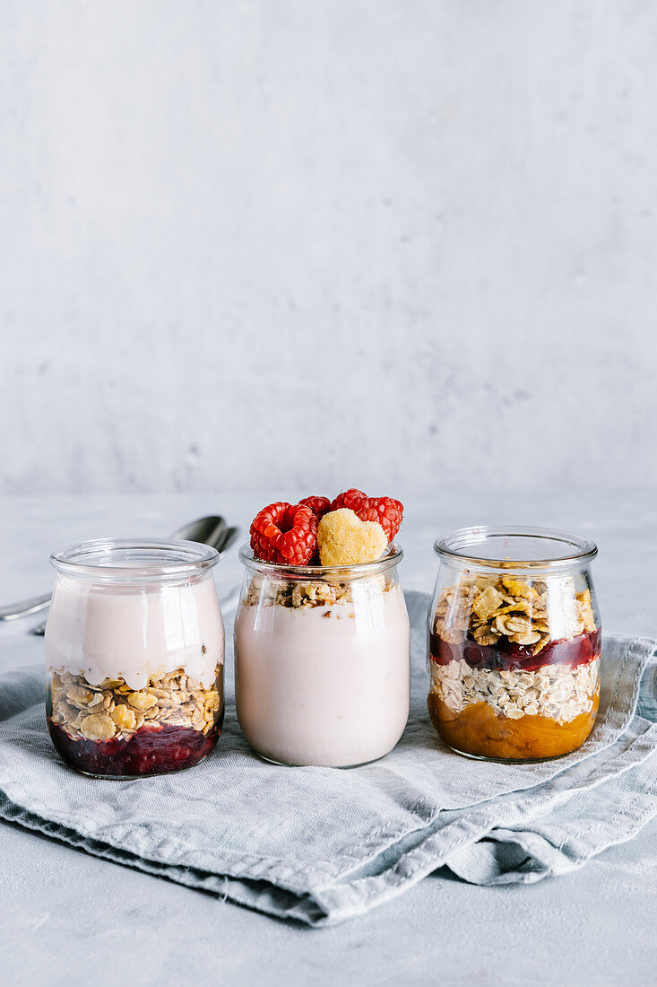 Healthy raspberry parfaits with yogurt in glass jars