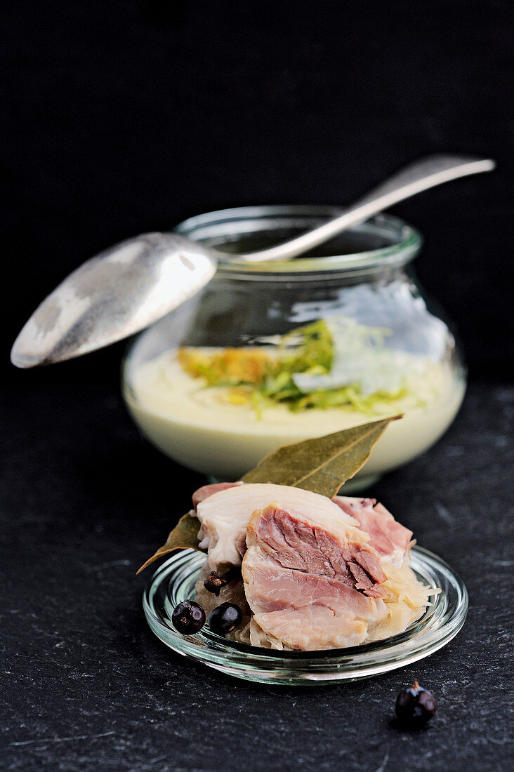 Pointed cabbage soup with pork knuckle ham and leek straw
