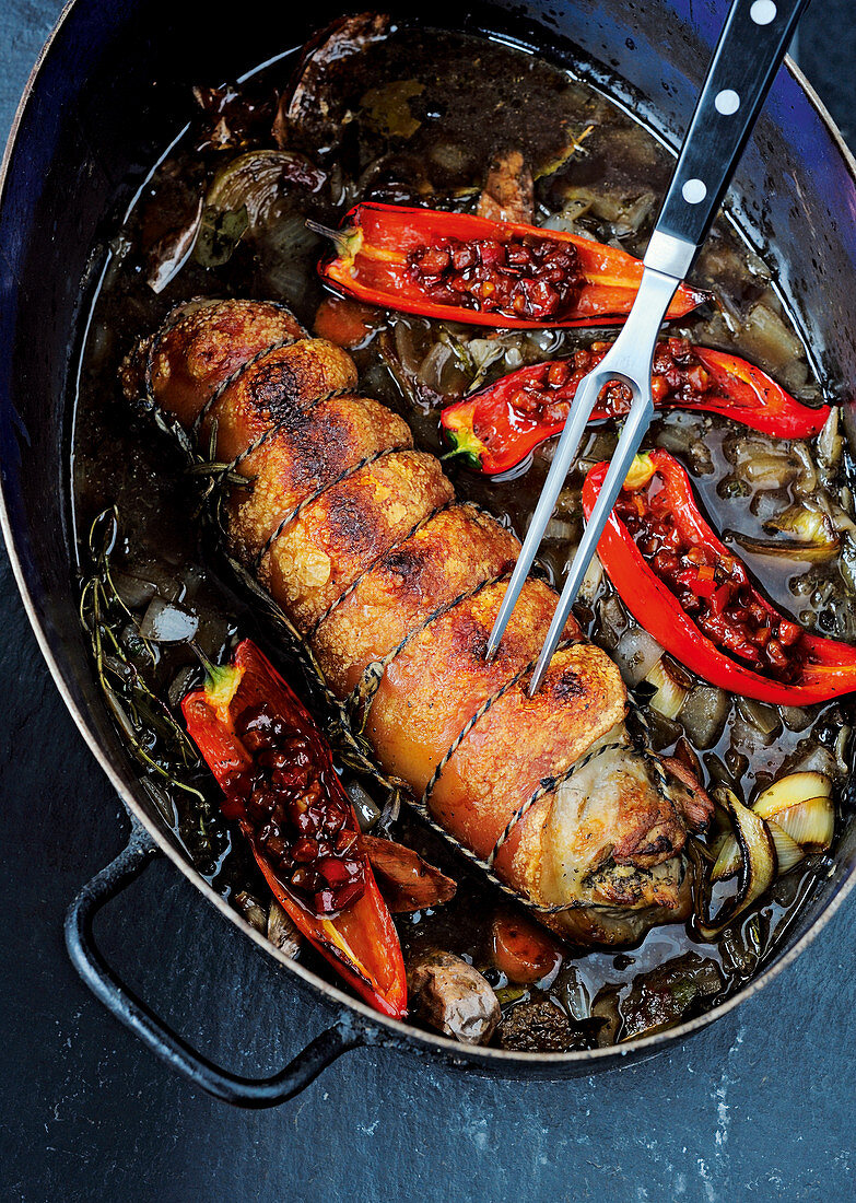 Porchetta with pointed peppers in a braising pot