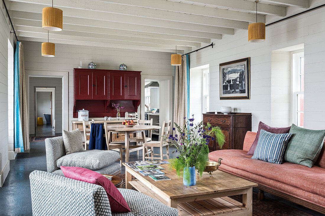 Beamed ceiling and furniture in living room of renovated 17th century stone cottage