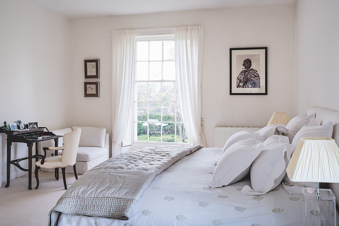 Bett mit Seidendecke, Schreibtisch und französischer Stuhl mit Seidenpolsterung im Schlafzimmer