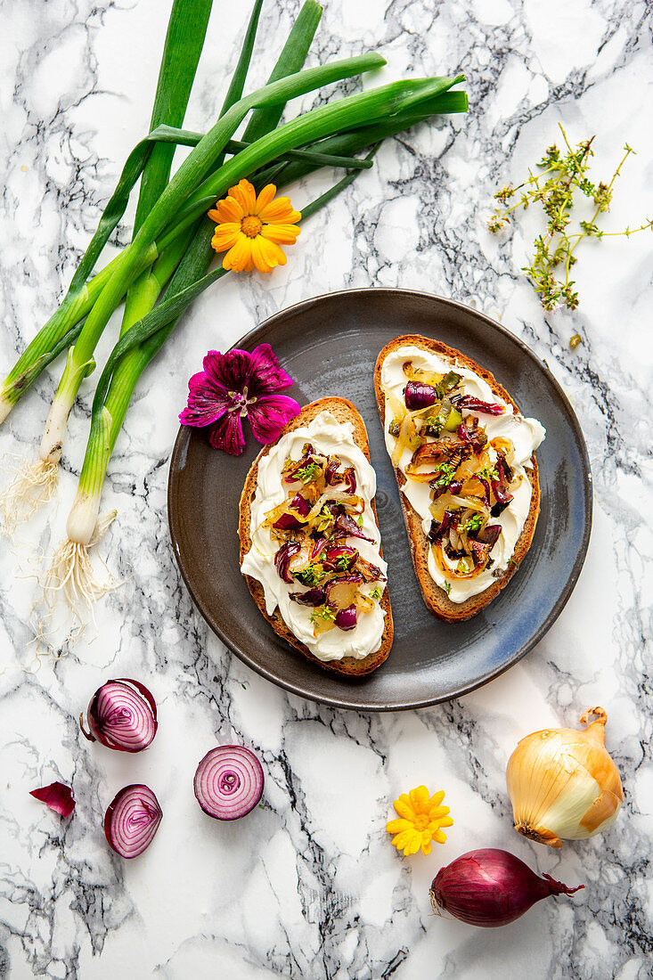 Brot mit Frischkäse und sautierten Zwiebeln