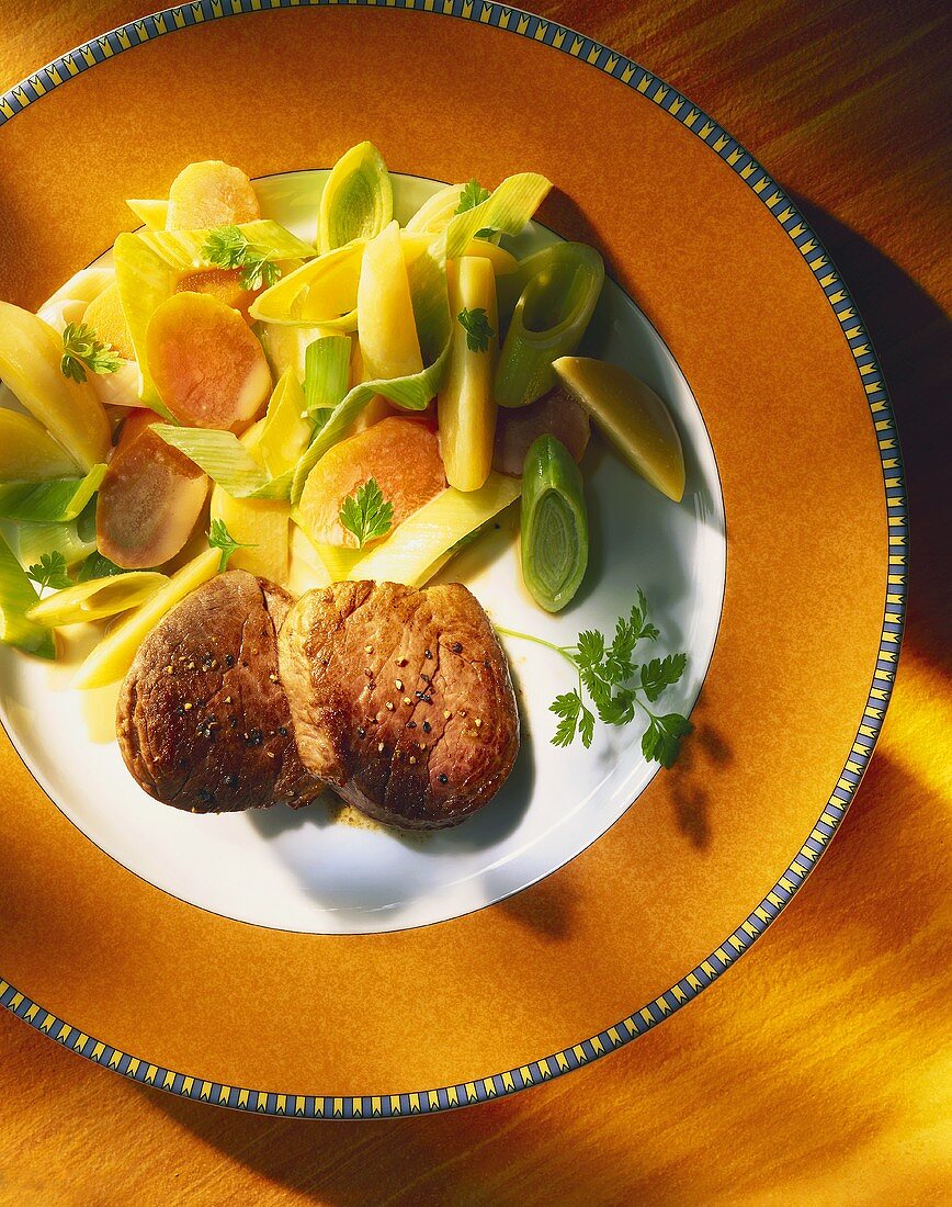 Fried beef medallions with carrots, leeks and potatoes