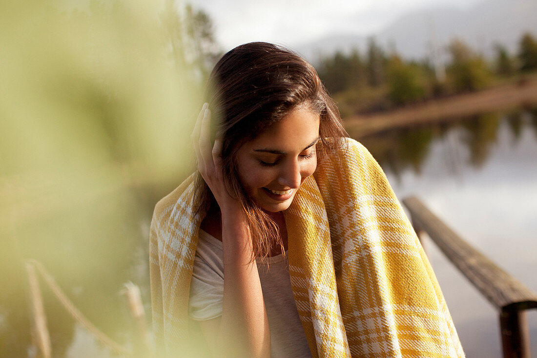 Smiling woman wrapped in blanket
