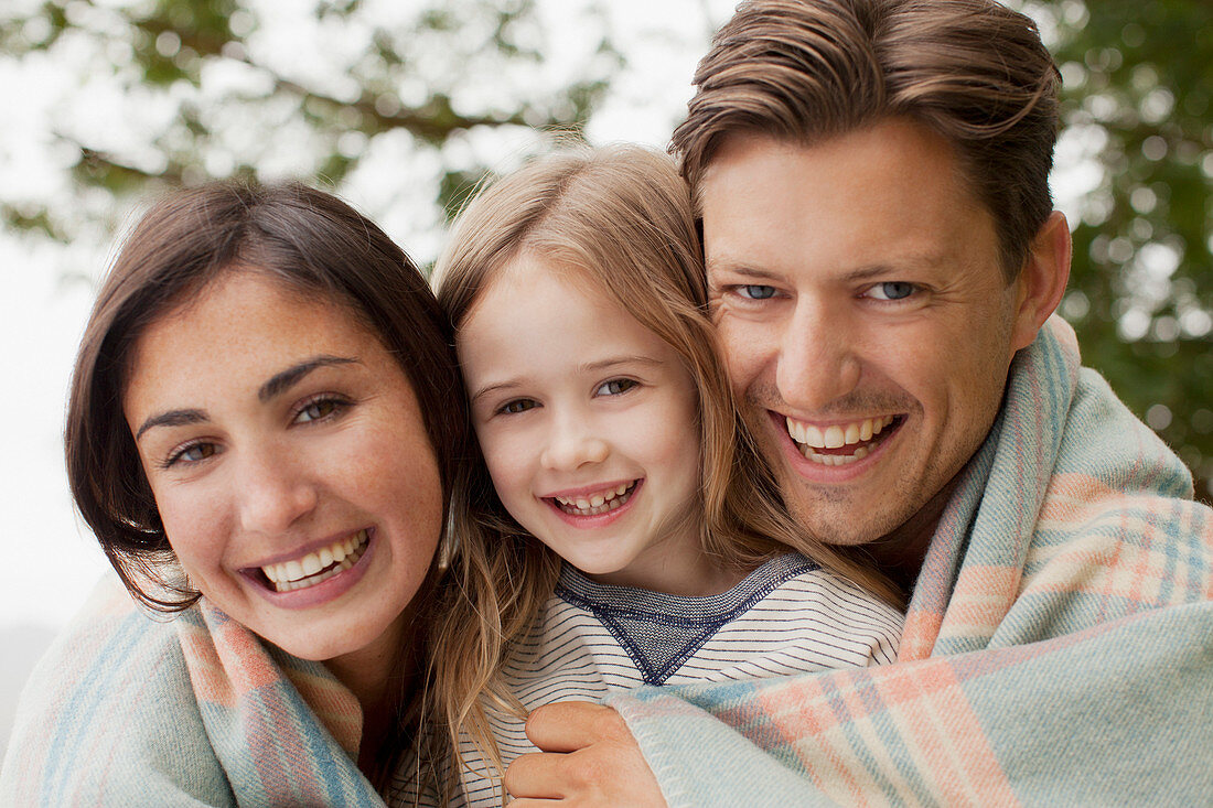 Smiling family wrapped in blanket