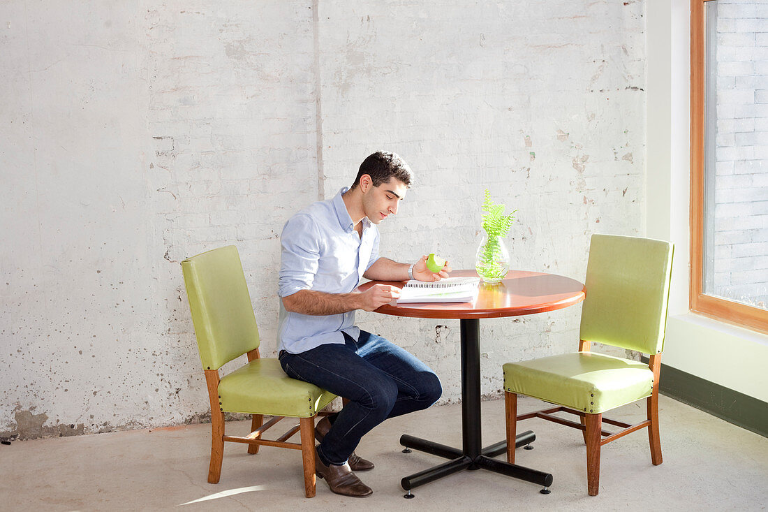 Businessman reading at table in office