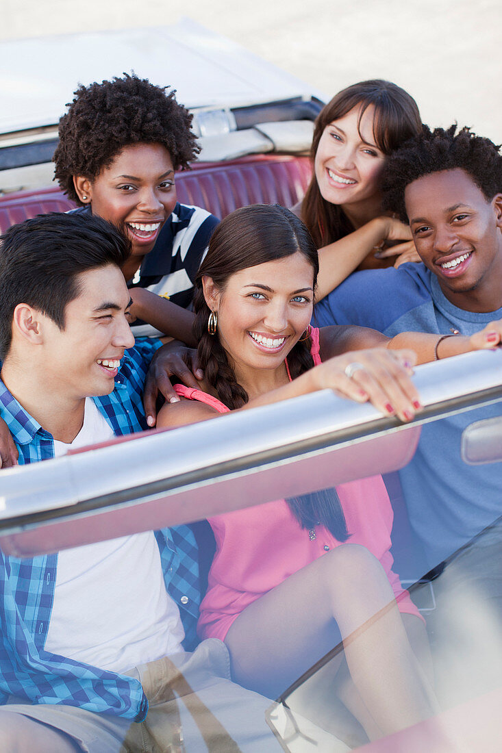 Smiling friends driving in convertible