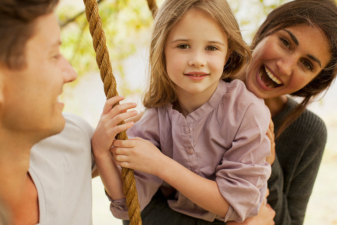 Portrait of happy family on swing