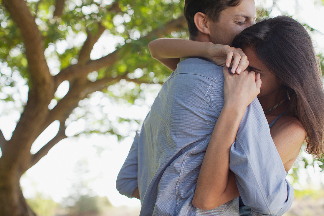 Couple hugging under tree