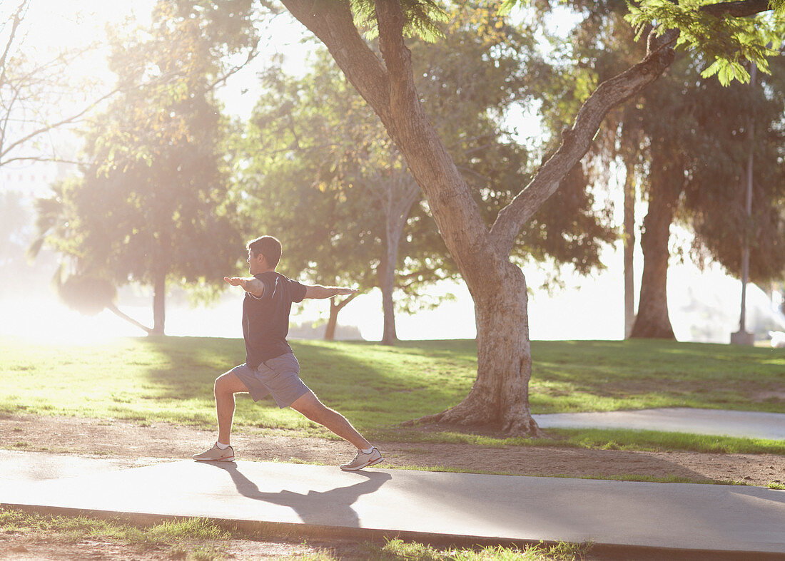 Man practicing yoga in park