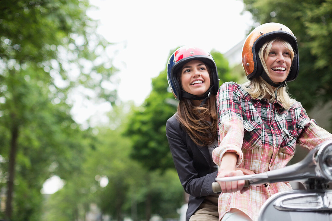 Women riding on scooter together