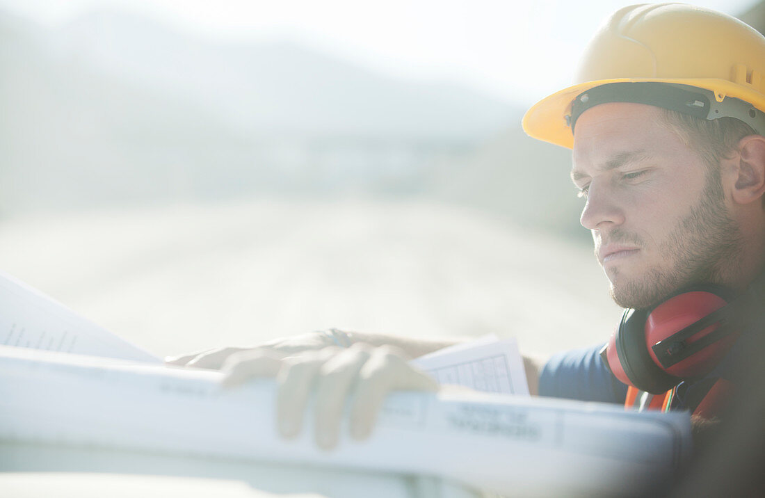 Worker reading blueprints on site